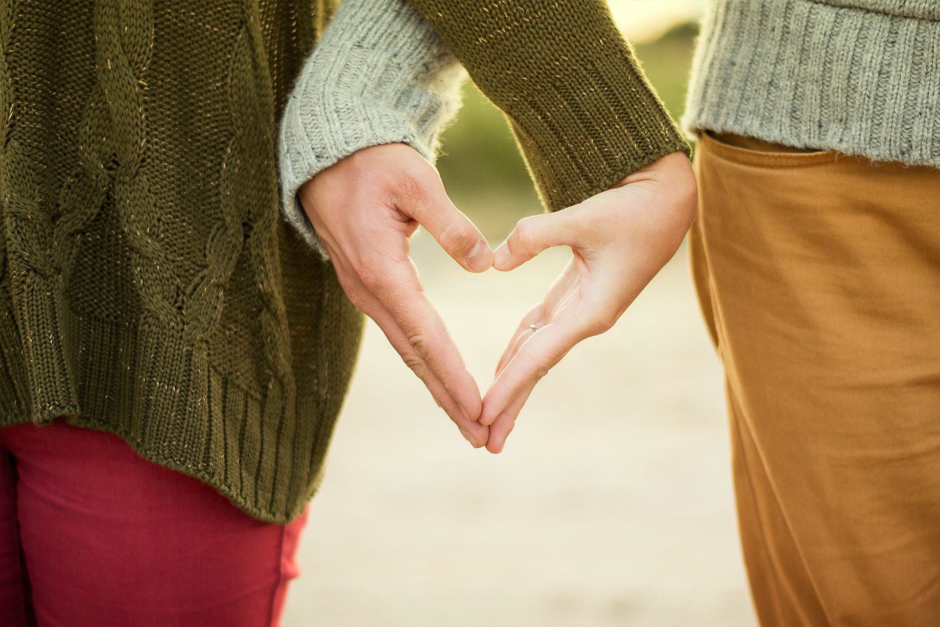 couple making a love heart with their hands combined