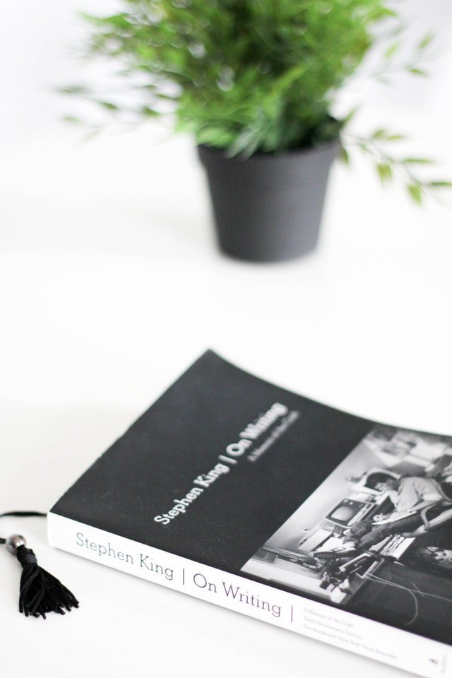 Stephen King's 'On Writing' on a desk with a potted plant - Photograph by J Kelly Brito for Unsplash