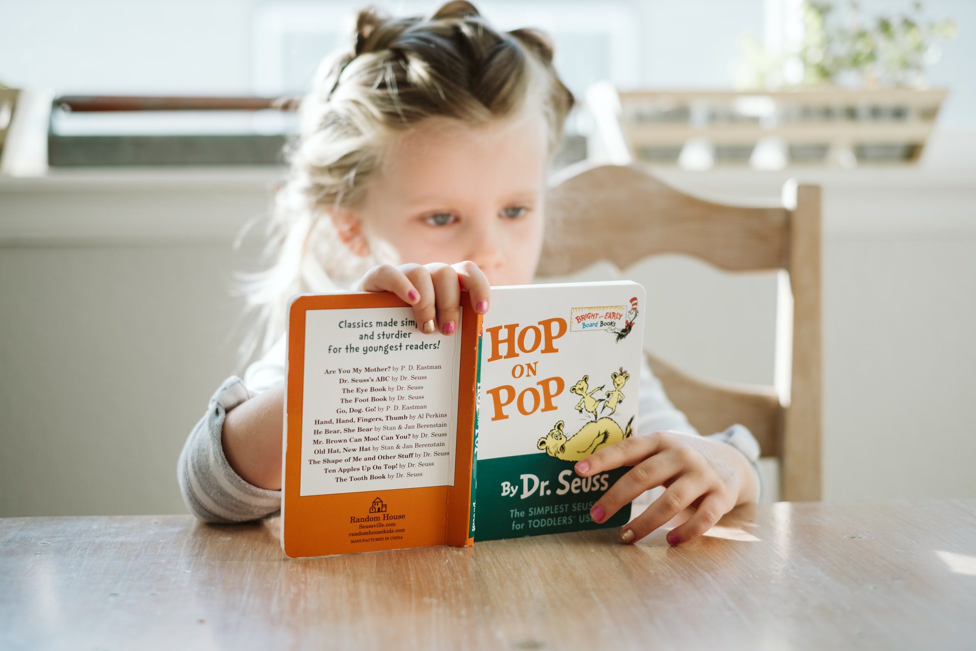 writing children's books - girl reading dr seuss - Photo by Josh Applegate on Unsplash