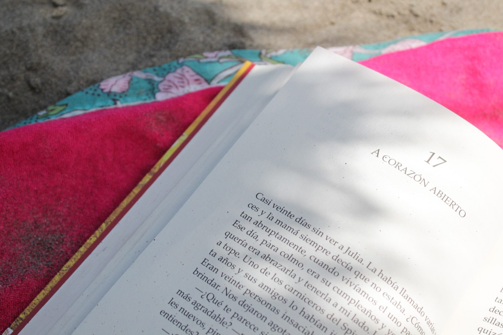 An open book on a blanket at the beach