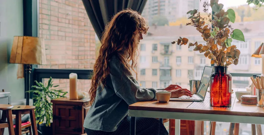 Young woman typing at a window